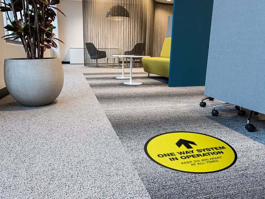 Social Distancing Sticker for Carpet Tiles that says "One Way System in Operation" in an office