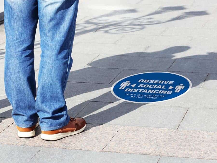 Social Distancing Sticker for outdoor usage that says "Observe Social Distancing" on a paved ground