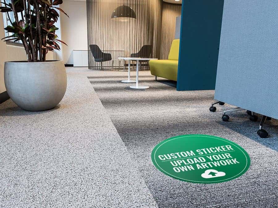 a round green and white sticker applied to an office carpet, with the words "custom sticker - upload your own artwork"
