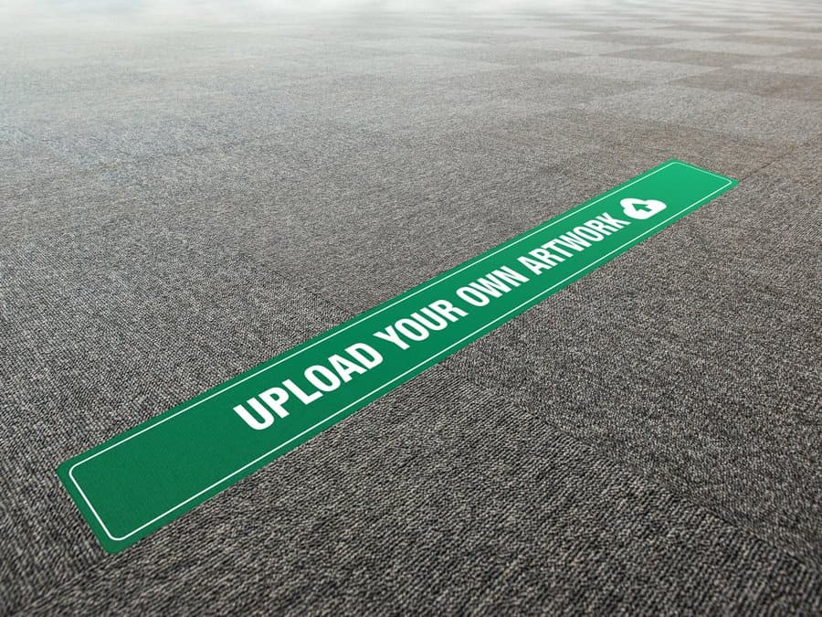 A long, rectangular and green and white social distancing sticker that says "upload your own artwork", on office carpet tiles