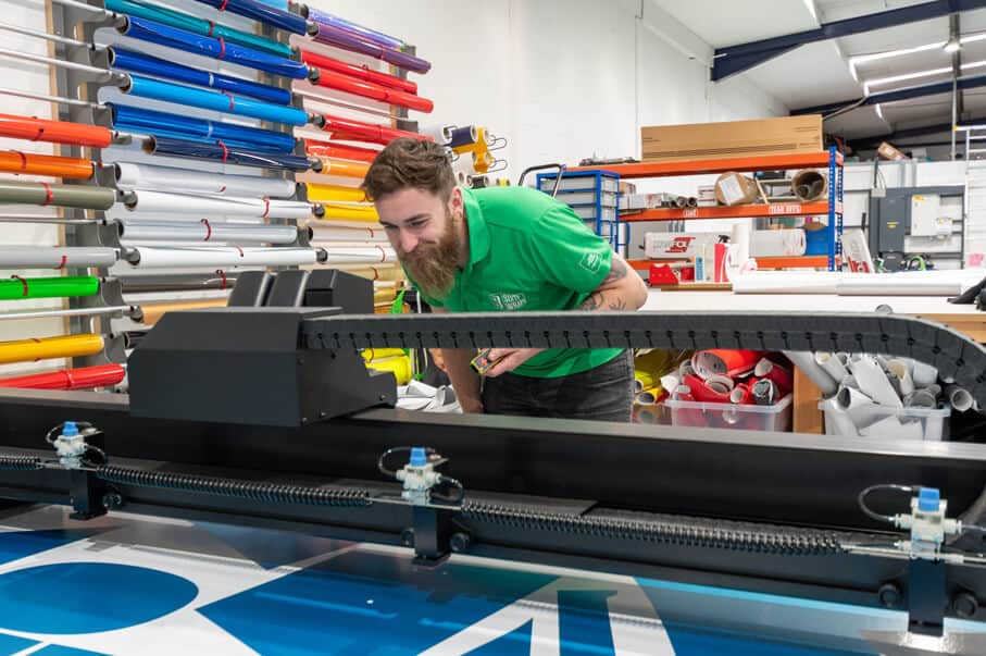 Man opperating a large vinyl cutting machine